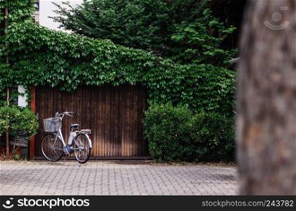 MAY 27, 2013 Takayama ,Gifu, Japan - Old vinatge bicycle at Sanmachi Suji in front of old wooden door covered with green vine plant famous Takayama old town.