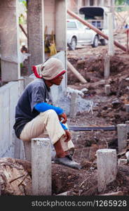 MAY 8, 2010 Bangkok, Thailand - Asian male construction labour sit on concrete pillar at building construction site