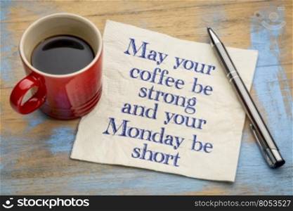 May your coffee be strong and your Monday be short - handwriting on a napkin with a cup of espresso coffee