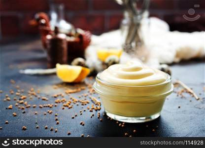 mayonnaise in glass bowl and on a table