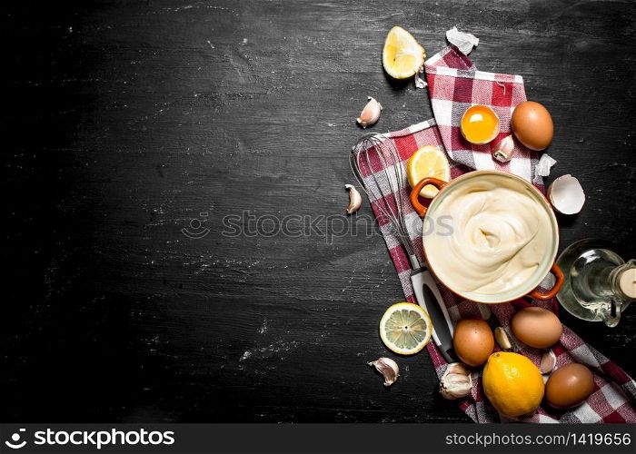 Mayonnaise with eggs , garlic, and lemon slices. On a black chalkboard.. Mayonnaise with eggs , garlic, and lemon slices.