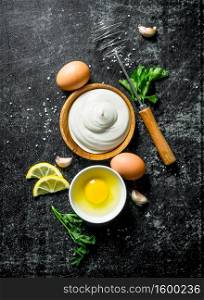 Mayonnaise with herbs, lemon and eggs. On dark rustic background. Mayonnaise with herbs, lemon and eggs.