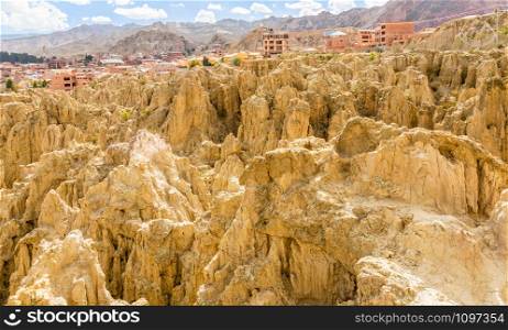 Maze of Moon Valley or Valle De La Luna eroded sandstone spikes, with La Paz city suburb in the background, Bolivia
