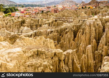 Maze of Moon Valley or Valle De La Luna eroded sandstone spikes, with La Paz city suburb in the background, Bolivia