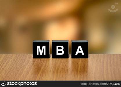 MBA or Master of Business Administration on black block with blurred background
