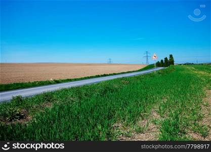 meadow and power line against the blue sky
