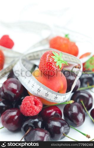 measure tape,strawberry, apricot, cherry and raspberry isolated on white