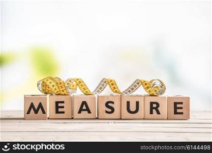 Measure word on a wooden table with measure tape