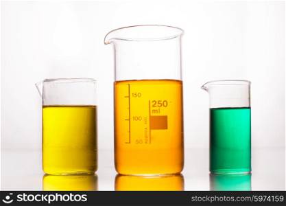 Measuring Beaker with color liquids on a white. Measuring Beakers