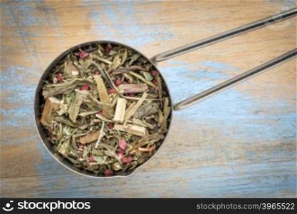 Measuring scoop of a Breathing and bronchitis herbal tea including ginkgo tea, lemon balm, lemon peel and green rooibos