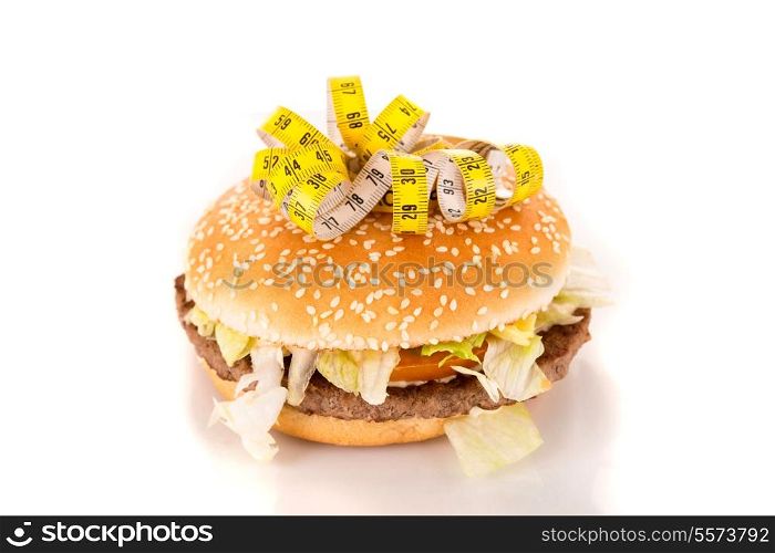 Measuring tape on the top of an appetizing hamburguer - diet concept