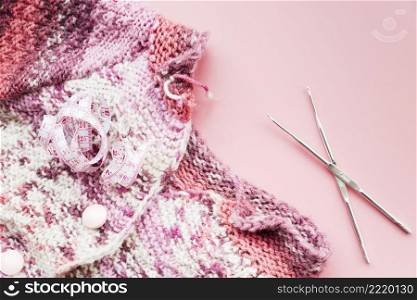 measuring tape with knitting crochet needles pink backdrop