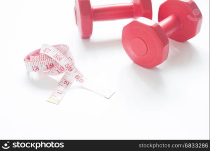 Measuring tape with red dumbbells isolated on white background with copys space, Healthy lifestyle and working out concept