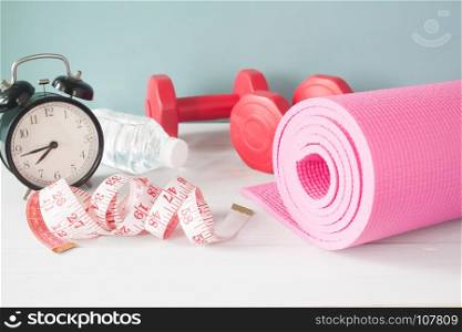 Measuring-tape, Yoga mat, dumbbells and alarm clock, Diet and Fitness concept