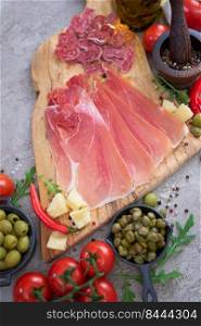 Meat antipasto platter on stone table - Sliced fuet salami sausage, prosciutto or jamon ham.. Meat antipasto platter on stone table - Sliced fuet salami sausage, prosciutto or jamon ham