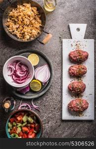 Meat balls cooking preparation with rice dish and salad on rustic kitchen table background, top view