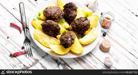 Meat balls with baked potatoes. Meat cutlets and fried potatoes for garnish