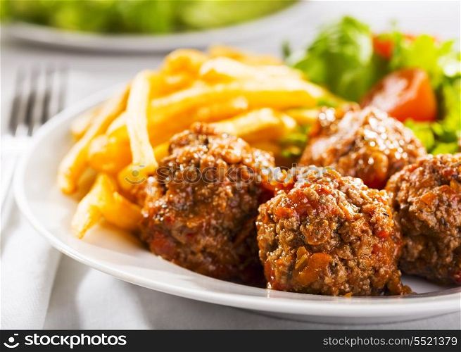 meat balls with fries and salad
