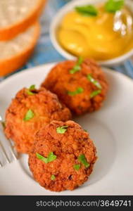 meat balls with mustard on white dish