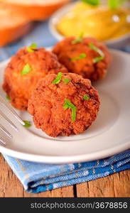 meat balls with mustard on white dish on wooden backgrounds