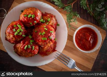 Meat balls with tomato sauce and herbs. Appetizing meat balls from eco products on a wooden background. Meat balls with tomato sauce and herbs