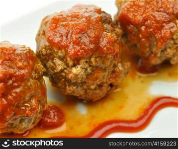 meat balls with tomato sauce on white dish, close up
