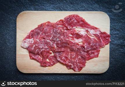Meat beef slice on wooden cutting board for cooked or Sukiyaki Shabu shabu Japanese foods Asian cuisine / Fresh beef raw