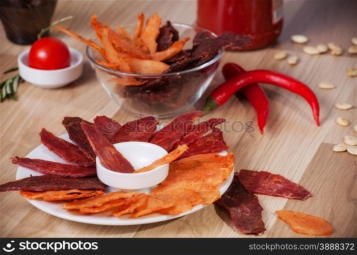meat chips on a plate with pepper pumpkin seeds and pepper