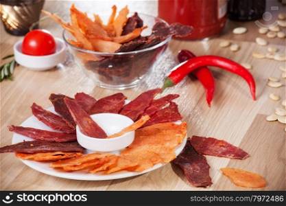 meat chips on a plate with pepper pumpkin seeds and pepper
