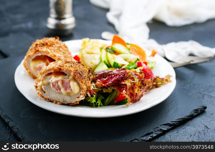 meat cutlet cordon bleu, cutlet with fresh salad on plate