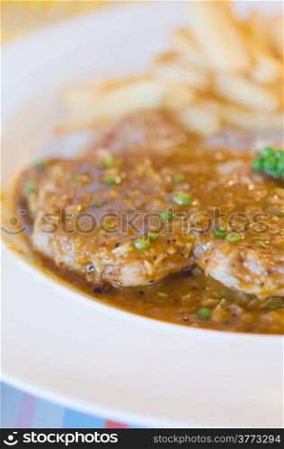 meat dish. close up beef steak with green peppercorn sauce served with chips and vegetable