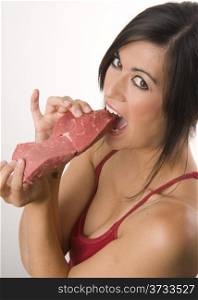 Meat Eater Woman Bites Big Slab of Red Steak Sirloin. Beautiful Brunette holds raw red steak meat