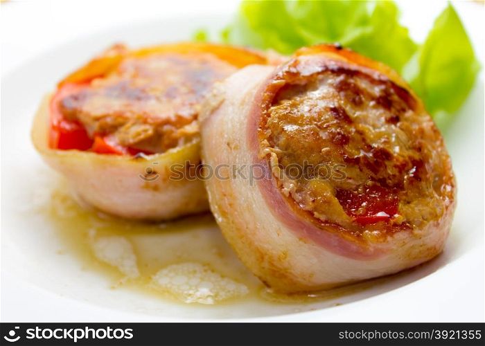 Meat medallions wrapped bacon with vegetable garnish