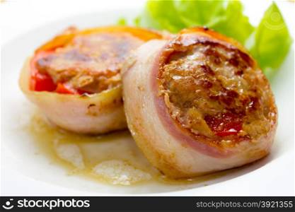 Meat medallions wrapped bacon with vegetable garnish