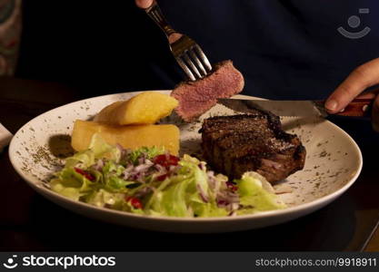 Meat on plate with salad and cassava