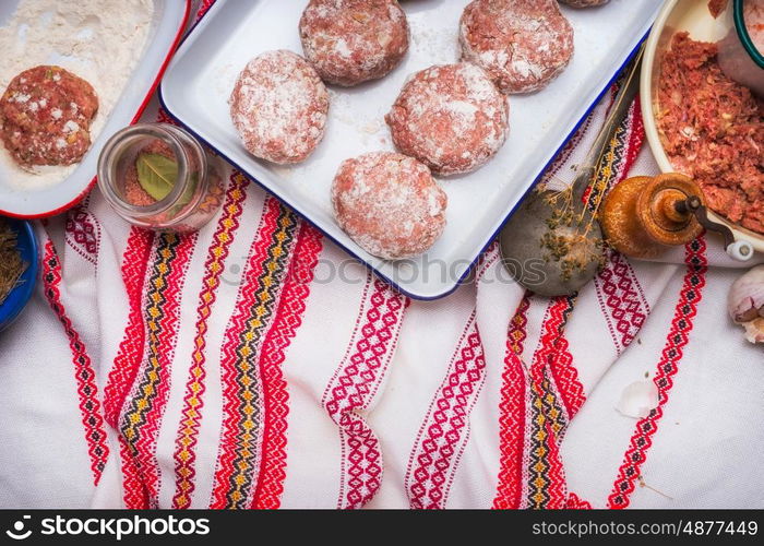 Meat patties cooking preparation with minced meat, flour and seasoning on traditional kitchen napkin , top view