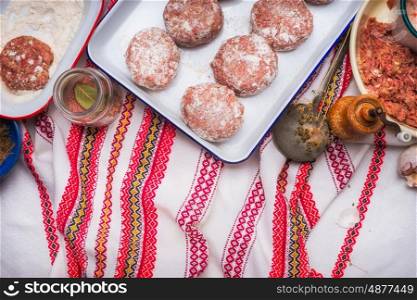 Meat patties cooking preparation with minced meat, flour and seasoning on traditional kitchen napkin , top view