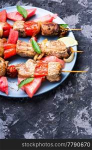 Meat, shish kebab on skewers with watermelon..Oriental cuisine. Shish kebab with watermelon