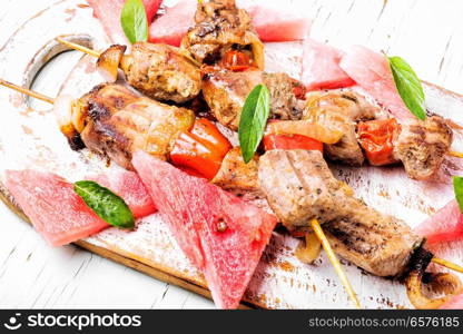 Meat, shish kebab on skewers with watermelon. Summer recipe for shish kebab. Shish kebab with watermelon garnish