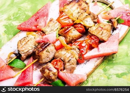 Meat, shish kebab on skewers with watermelon. Summer recipe for shish kebab. Shish kebab with watermelon garnish