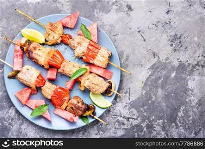 Meat, shish kebab on skewers with watermelon. Summer recipe for shish kebab.Eastern food. Kebab,grilled meat with watermelon