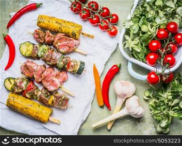Meat Skewers for grill with vegetables , corn ears and condiment, preparation on rustic background , top view
