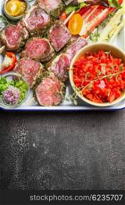Meat skewers with vegetables and fresh seasoning on dark rustic background, top view, vertical, border