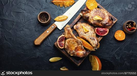Meat steak, pork, cutlet on the bone fried in a citrus marinade.. Steak on the bone grilled with citrus fruits.