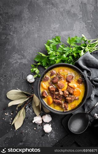 Meat stew, goulash in a cast iron pot, top view