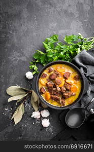 Meat stew, goulash in a cast iron pot, top view