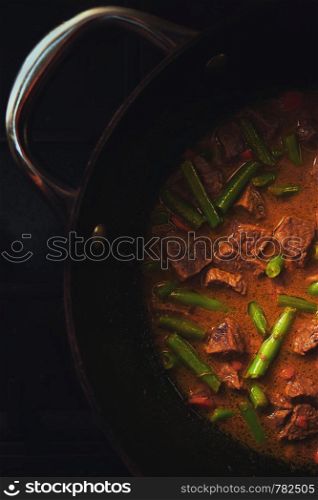 Meat stew with vegetables in an old deep pan