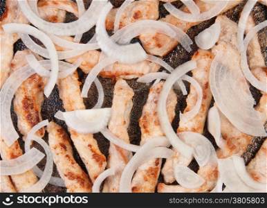Meat Strips Fried With Onion In A Black Pan
