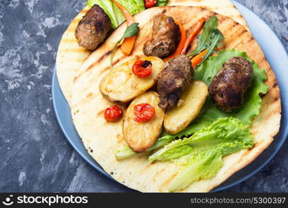 meat tortilla dish. Tortilla dish with meat sausages on blue stone background