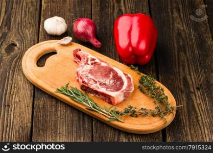meat, vegetables and spices on wooden background
